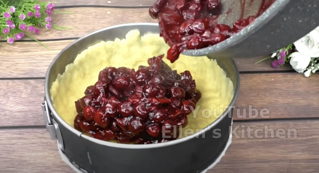 Mirisna torta od trešnje s pahuljastom vrhnjem i hrskavom, zlatnom mrvicom na površini.