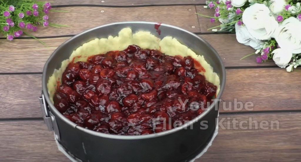 Mirisna torta od trešnje s pahuljastom vrhnjem i hrskavom, zlatnom mrvicom na površini.